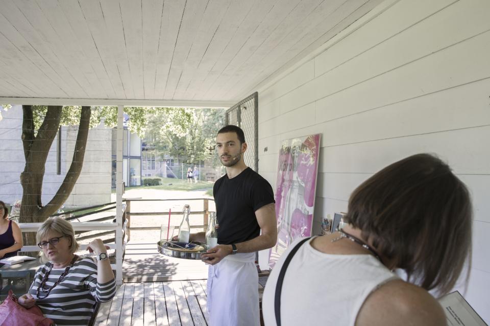 artist holding serving tray and singing on veranda