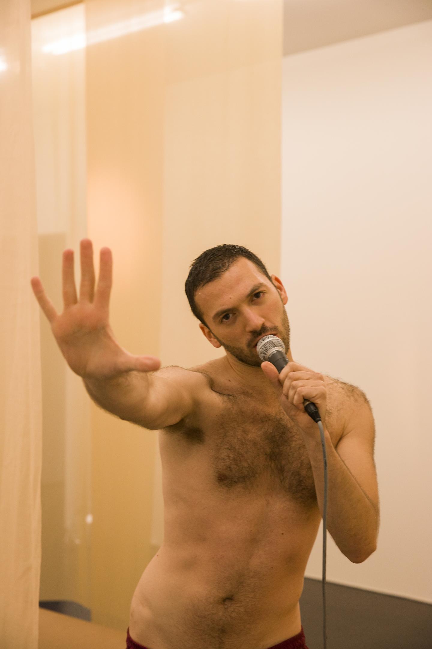 artist stretching arm towards audience while speaking into microphone