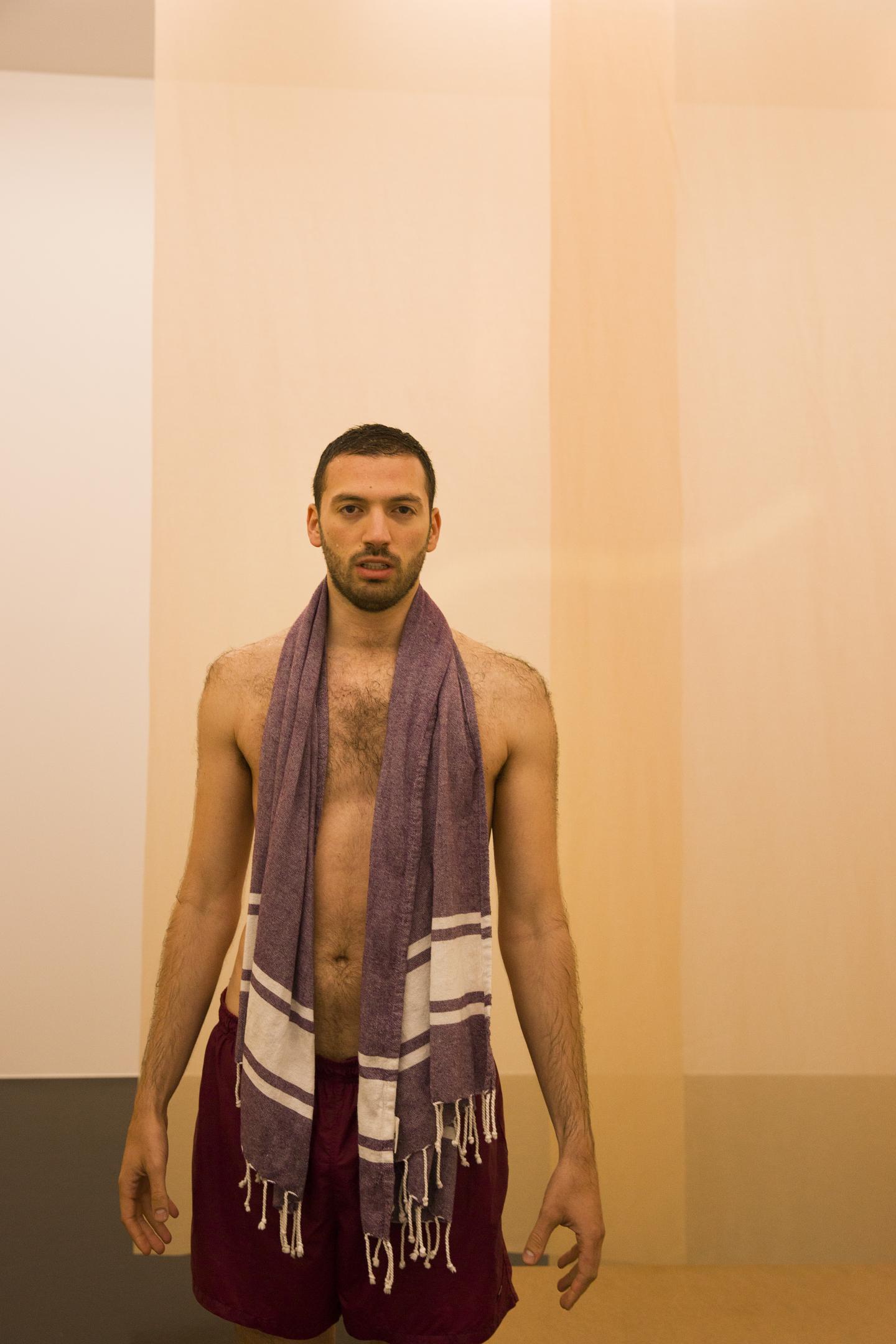 artist gazing at audience, in front of transparent curtains