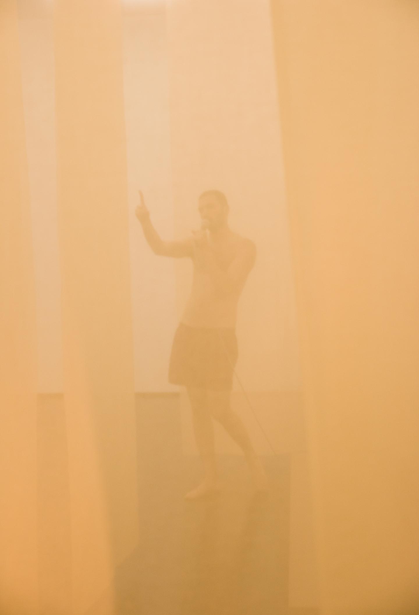 artist pointing finger behind transparent curtain