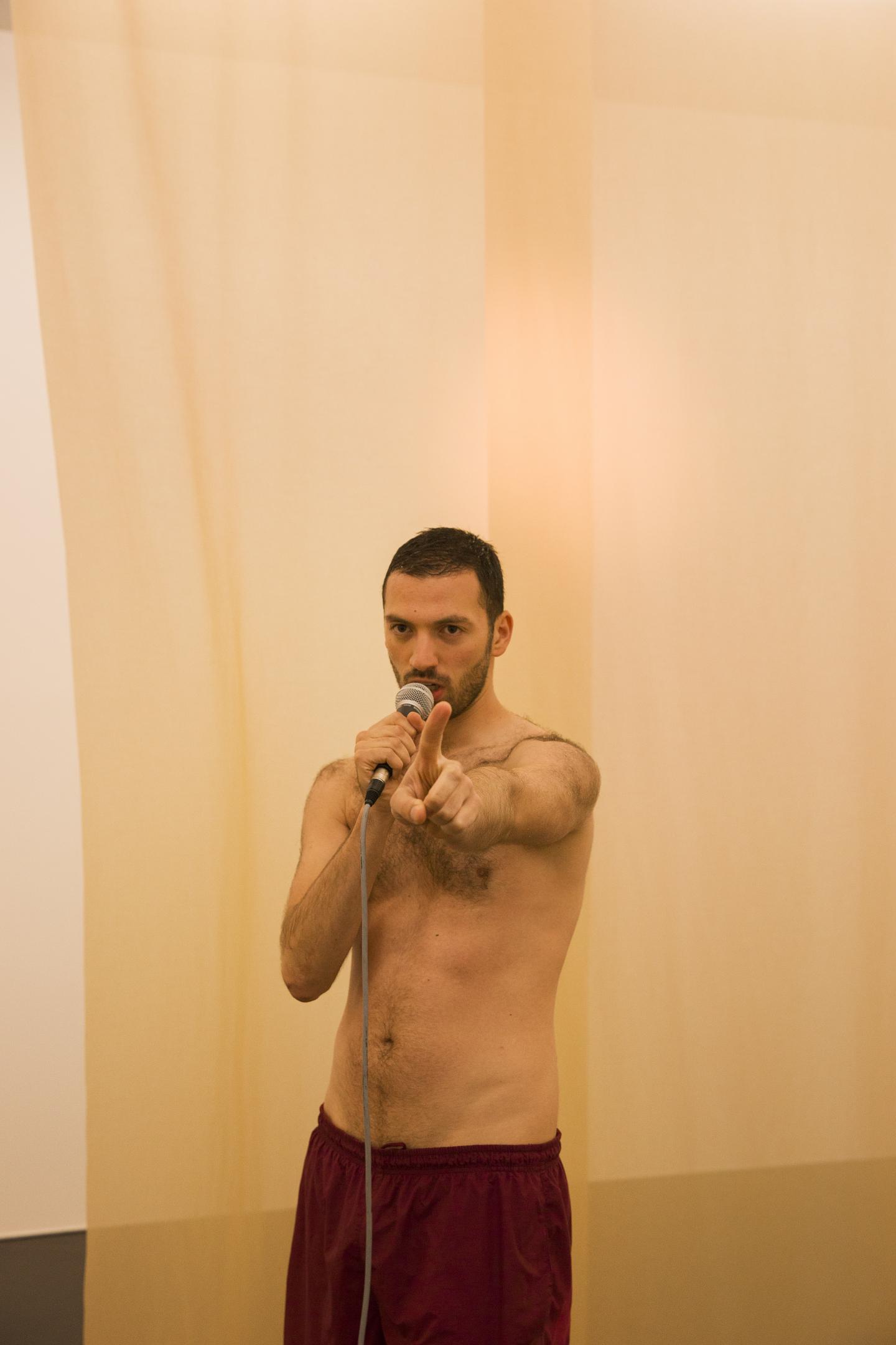 artist pointing finger to audience in front of transparent curtain